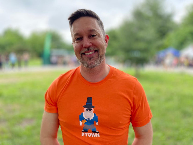 A smiling man in the orange PTown Crier tee